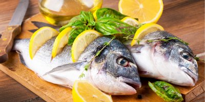 Dvě ryby na prkénku proložené citronem