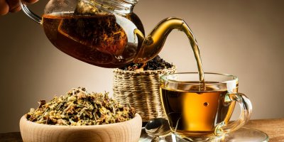 Z konvičky teče čaj do hrnečku