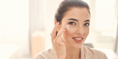 Žena si aplikuje krém na tvář