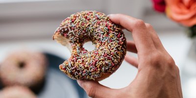 Ruka držící nakousnutý donut