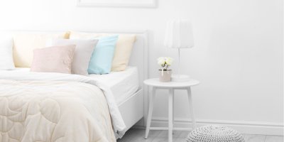 Světlá ložnice s postelí a nočním stolkem