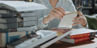 Žena studuje velké množství knih