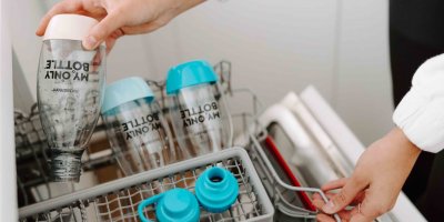 Žena dává do myčky na nádobí sklenice Sodastream 