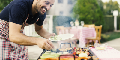 Muž griluje na zahradě