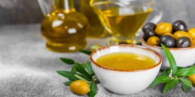 Olivový olej v keramické misce, ve skleněných nádobách, olivy