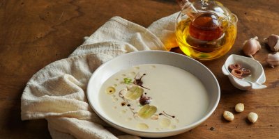 Bílá polévka a vedle ní česnek a ocet
