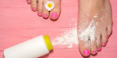 Nohy na podložce a vysypaný škrob z pudřenky