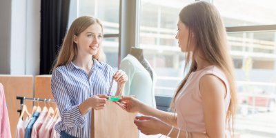 Žena platí kartou v obchodě