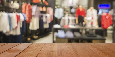 Prázdný regál v popředí obchodu s oblečením