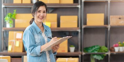 Žena za pultem s deskami v obchodě, kde se vydávají balíky