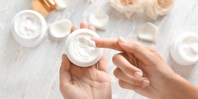 Ruce nabírají krém z kelímku