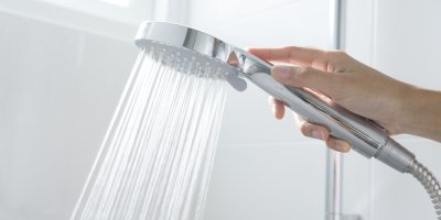 Ruka držící tekoucí sprchu