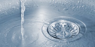 Voda odtékající do odtoku ve dřezu