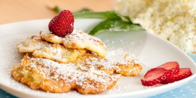 Smažené květy černého bezu posypané cukrem s jahodami