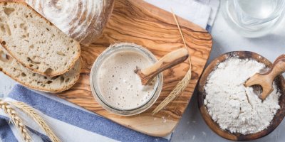 Startovací kvásek, nakrojený chleba, mouka v misce