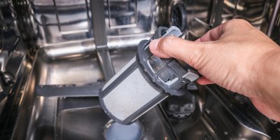 Muž vyndává filtr z myčky nádobí