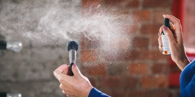 Žena čistí dezinfekcí štětec na make-up