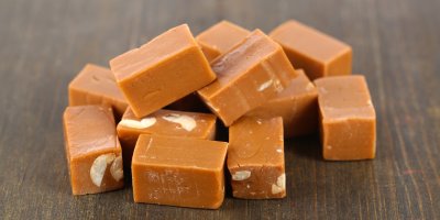 Karamelky s ořechy na dřevěném povrchu