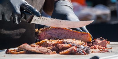 Muž krájí uzené maso