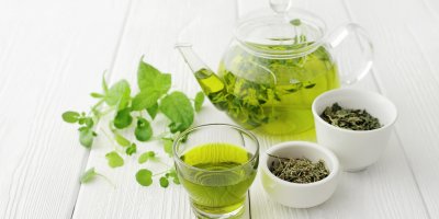 Uvařený zelený čaj v konvici a ve sklenici, sušený čaj v kalíšcích