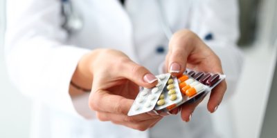 Lékařka drží čtyři plata léků