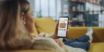 Žena si prohlíží na mobilu eshop s kabelkami 