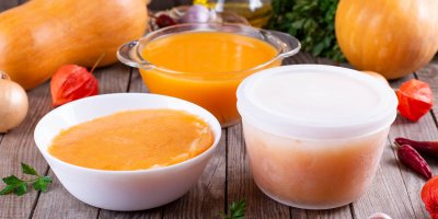 Dýně, dýňová polévka v miskách a zmrazená polévka v dóze
