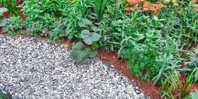 Záhon zasypaný kůrou, před ním je štěrk