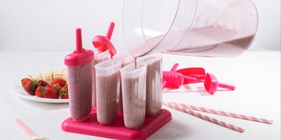 Šest tvořítek na nanuky, do kterých je vlévána směs na zmrzlinu, jahody, banány