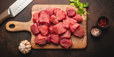 Kousky hovězího masa na prkénku s česnekem a kořením