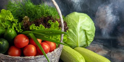 Kopr, rajčata, okurky, salát v košíku, vedle zelí a cukety