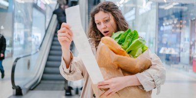 Žena si čte účtenku z obchodu a je z toho překvapená