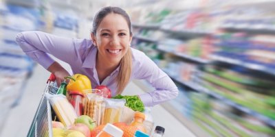 Žena jede rychle s nákupním vozíkem