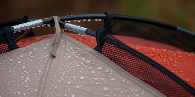 Detailní záběr na horní stranu stanu, která je mokrá od deště