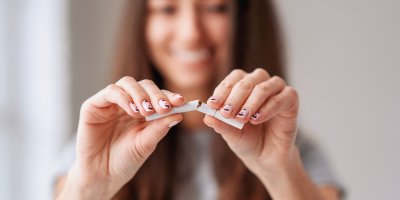 Usmívající se žena láme cigaretu