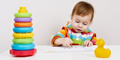 Batole kreslí obrázek, vedle sebe má plastové kroužky a kachnu