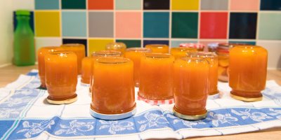 Sklenice s meruňkovou marmeládou otočené vzhůru nohama na utěrce