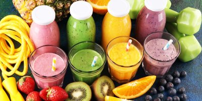 Uzavřené sklenice se šťávou z jahod, pomerančů a kiwi