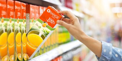 Ruka bere z regálu krabici s džusem v supermarketu
