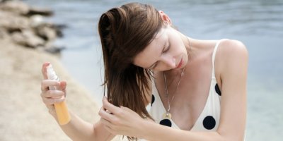 Žena si aplikuje sérum do mokrých vlasů