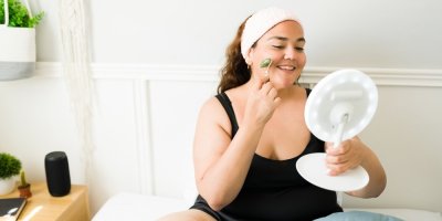 Žena s nadváhou pečuje o svou pleť před zrcadlem