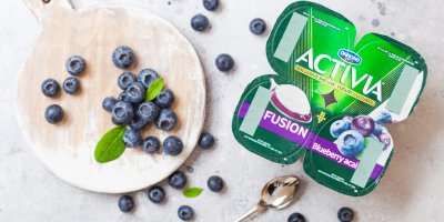 Čtyři jogurty Activia s příchutí borůvka acai, borůvky na prkénku, lžička