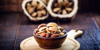 Miska s vyloupanými para ořechy a rozpůleným ořechem v pozadí