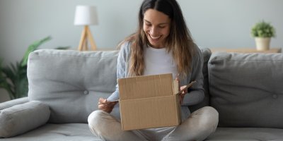 Nadšená žena se dívá na rozbalený balíček
