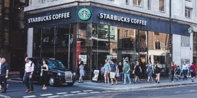 Dav lidí prochází kolem prodejny Starbucks