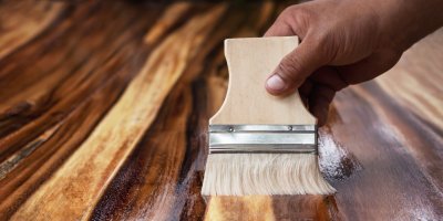 Ruka se štětcem pečuje o podlahu