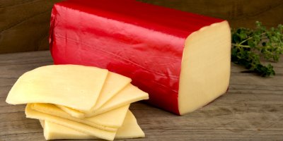Velký kus eidamu a eidam nakrájený na plátky