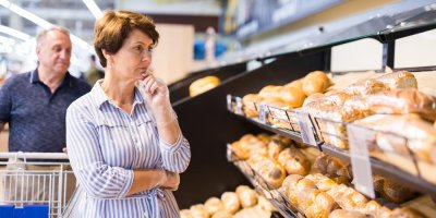 Žena je zamyšlená v supermarketu u pečiva