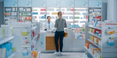 Žena si u lékárnice v lékárně kupuje léky