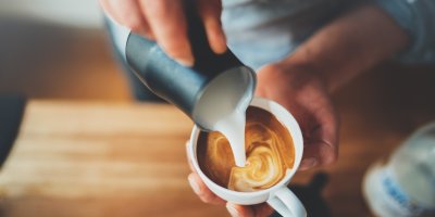 Detail nalévání smetany do šálku kávy